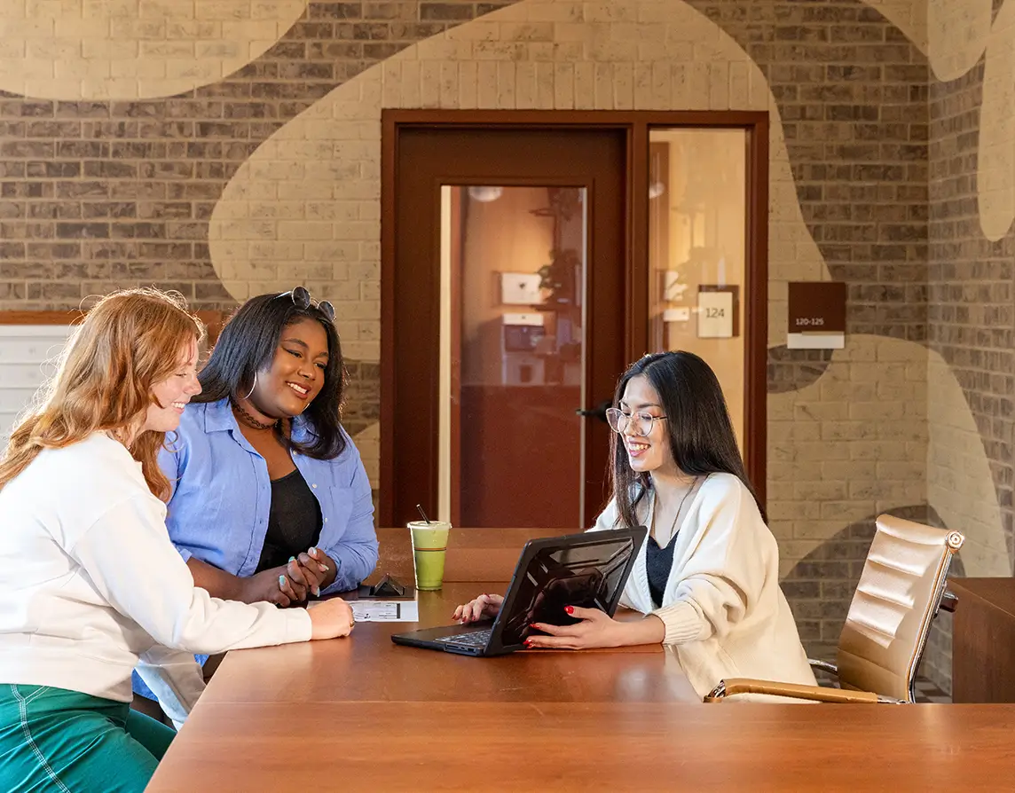 a group of people looking at a laptop