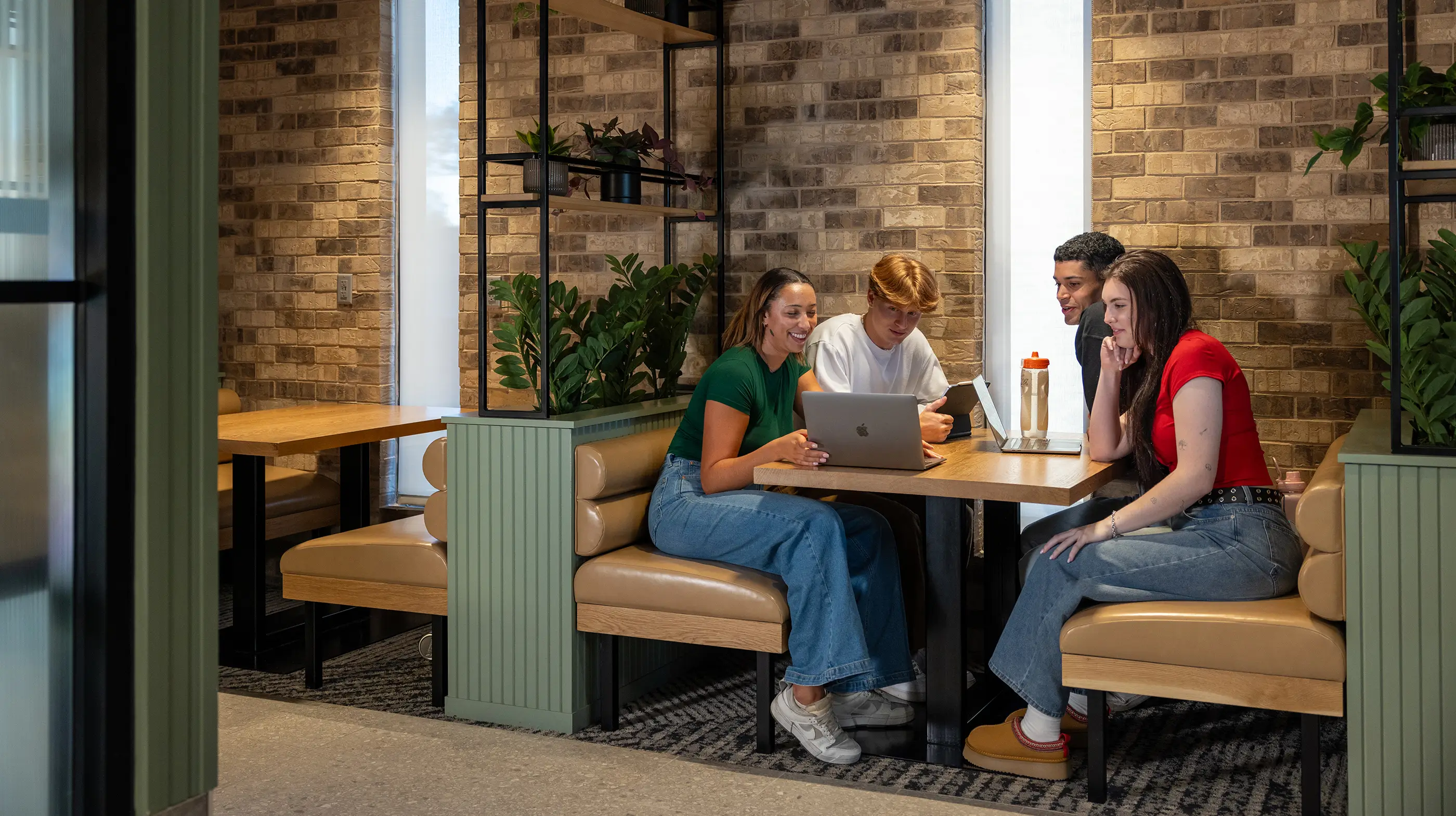 a group of friends looking at a laptop